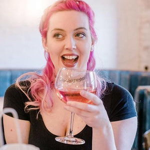 Cool lady with pink hair enjoys a delicious cocktail